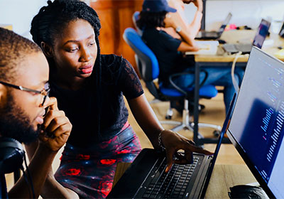 A man and woman looking at monitor